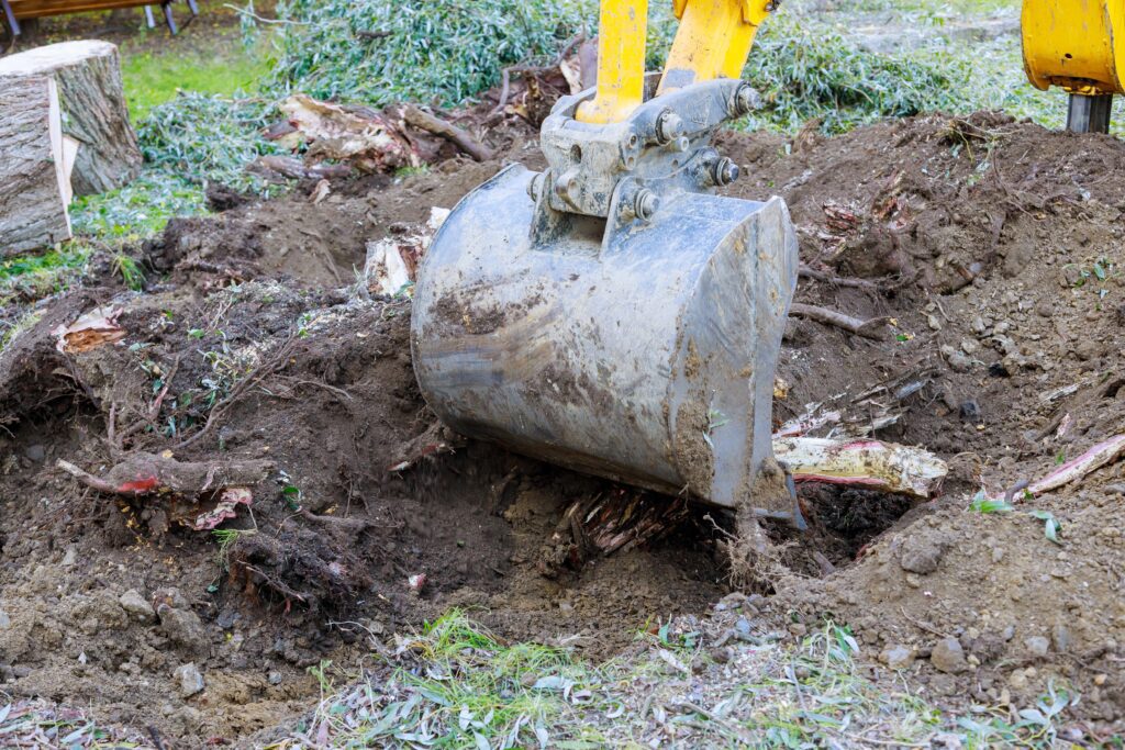 A yellow and black shovel in the dirt